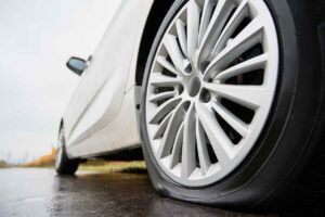 web-stopped-white-car-with-punctured-car-tire-roadside